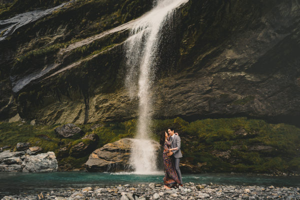 bride and groom on wedding day next to waterfall in Earnslaw Burn Queenstown New Zealand