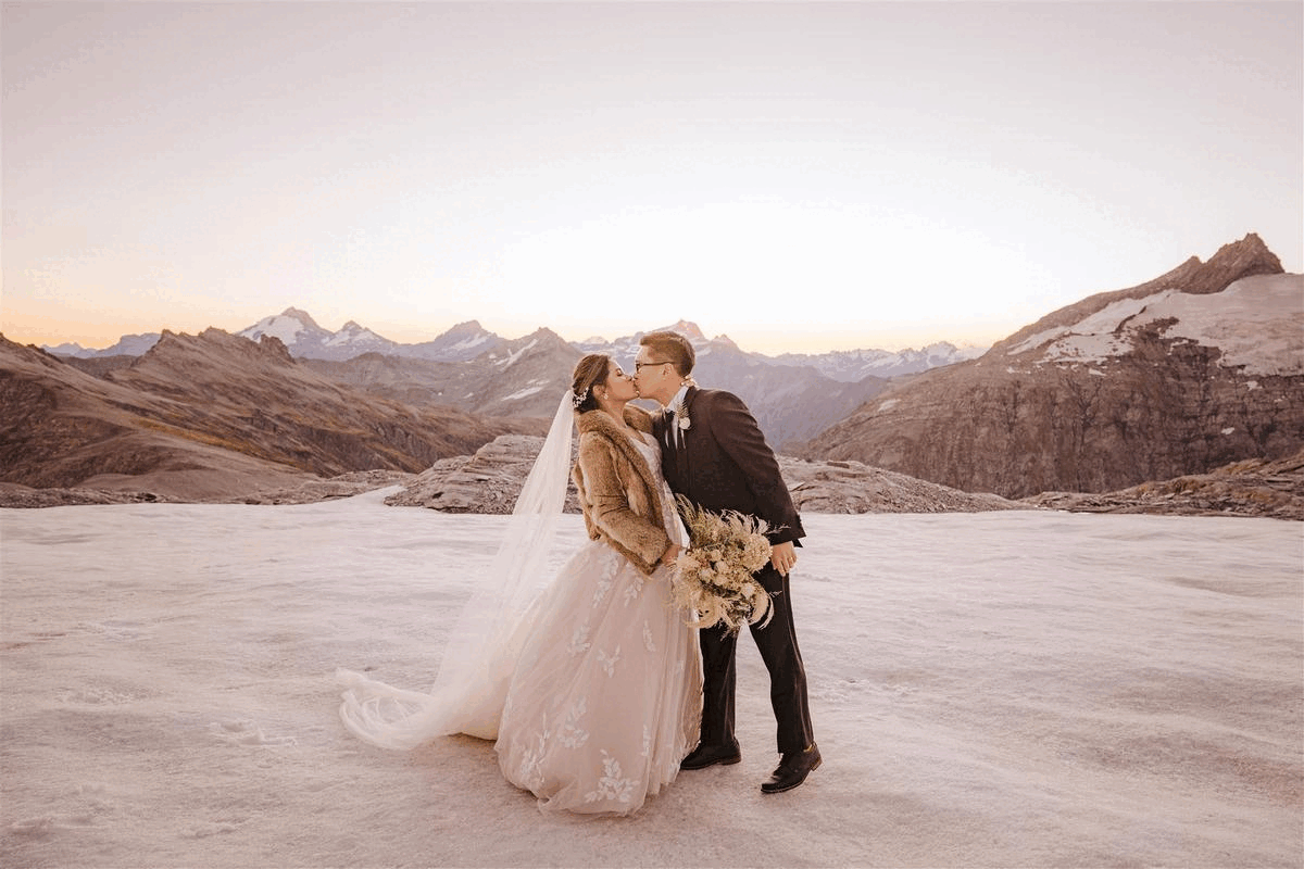 husband and wife kiss at Tyndall Glacier in Queenstown