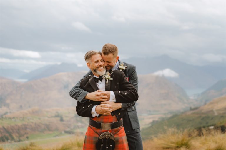Two grooms cuddle after their Queenstown elopement ceremony