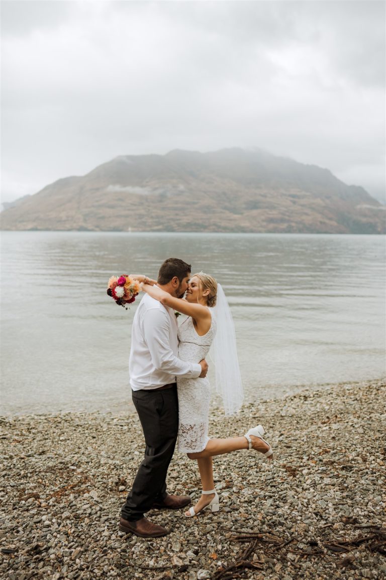 bride and groom kiss in the rain after wedding ceremony in Queenstown New Zealand