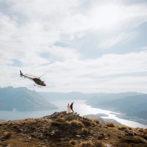 queenstown helicopter wedding at The Remarkables with lake and mountain views and helicopter flying in the background