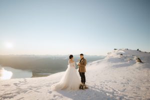 Bride and groom exchange vows during heli-wedding elopement ceremony in the snow at The Remarkables, Queenstown