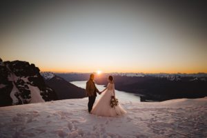 bride and groom watching the sunset in the snow on their wedding day at The Remarkables in Queenstown