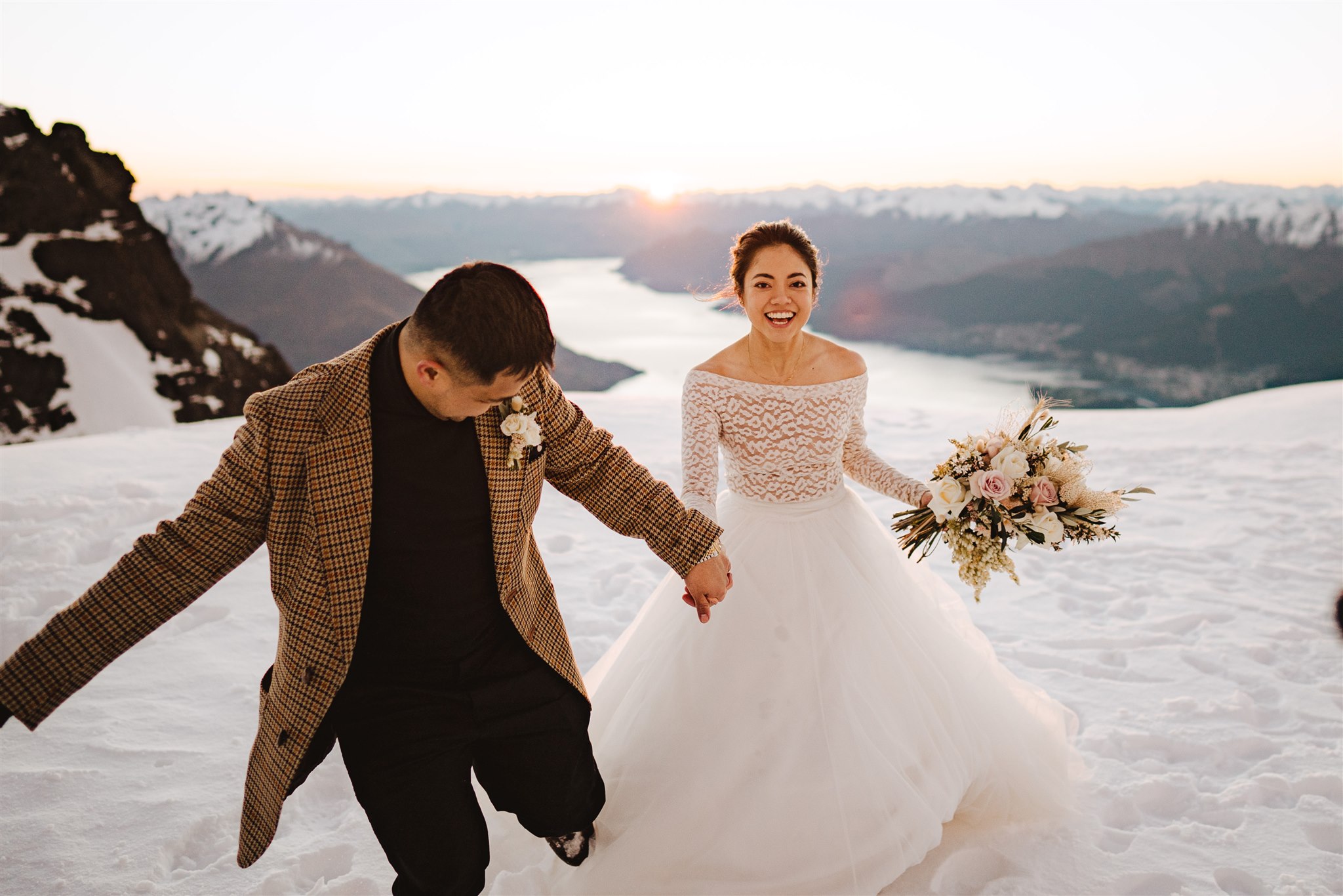 Bride and groom run towards the camera during wedding photoshoot at The Remarkables, Queenstown