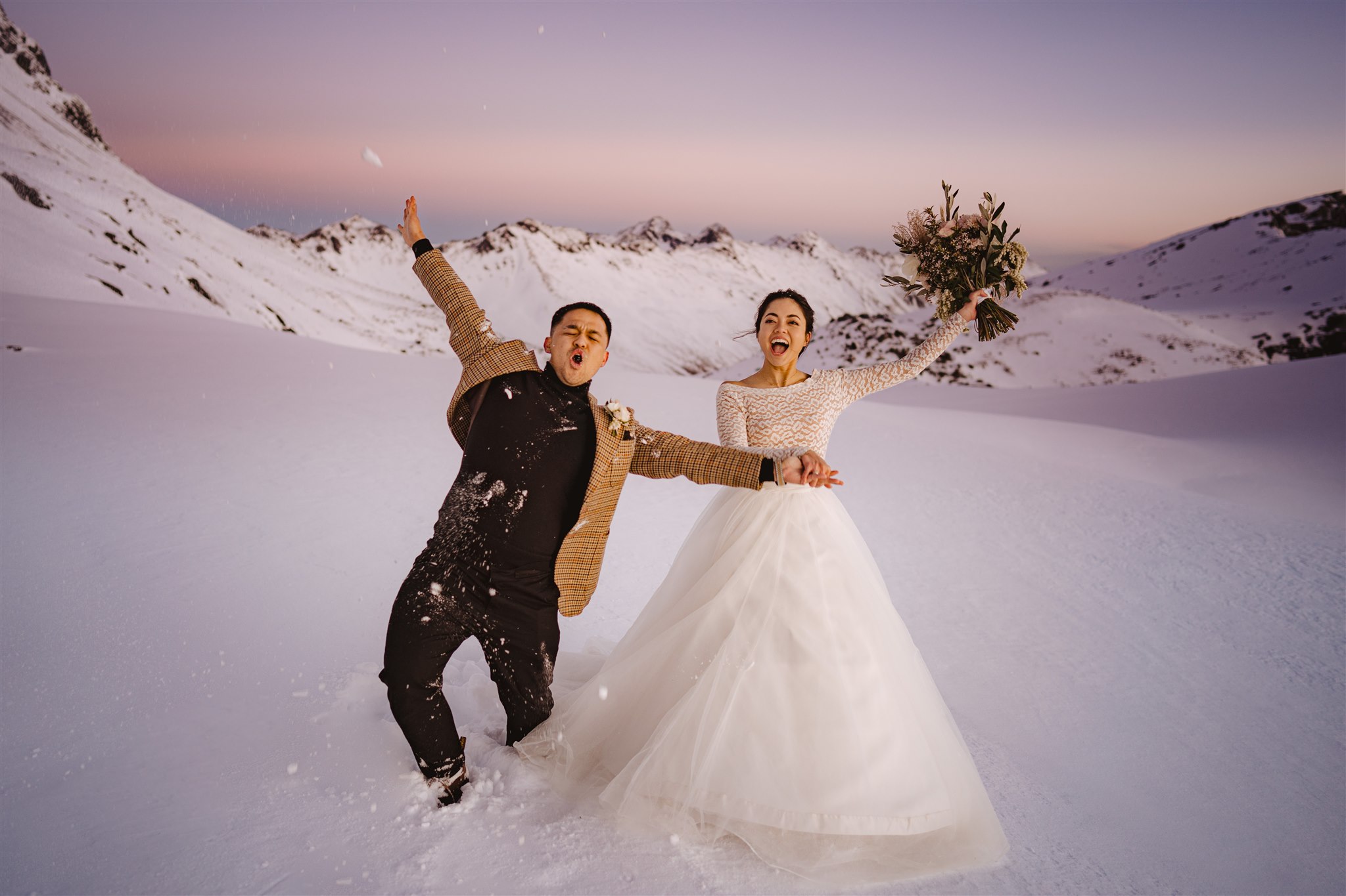 bride and groom celebrate as newlyweds in the snow at The Remarkables Queenstown