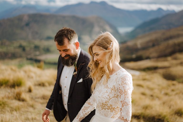 Bride and groom laughing and walking together in the mountains of Queenstown New Zealand
