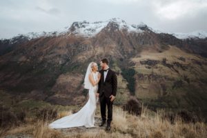 bride and groom on mountain in wedding clothes in Queenstown, New Zealand