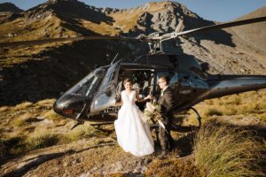 bride and groom getting out of helicopter at Lochnagar for heli-wedding in Queenstown