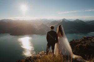 bride and groom soak in the view from top of cecil peak mountain in queenstown new zealand