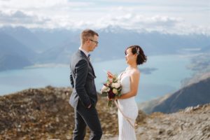 bride reads wedding vows with groom during mountain top wedding ceremony at Mount Crichton in Queenstown New Zealand