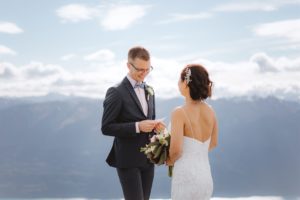 groom shares wedding vows with bride during mountain wedding at Mount Crichton, Queenstown, New Zealand