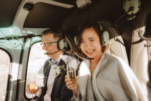 bride and groom holding champagne in a helicopter after helicopter wedding ceremony