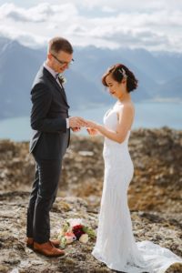 bride and groom exchanging wedding rings at mountain top ceremony at Mount Crichton, Queenstown, New Zealand