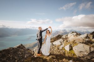 bride and groom dancing on mountain top, Mount Crichton, Queenstown, New Zealand