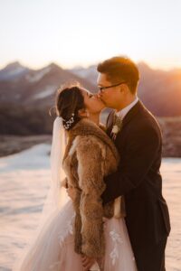 bride and groom kiss at sunset in sdnow at Tyndall Glacier in Queenstown New Zealand