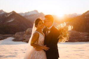 bride and groom smile and kiss at sunset on Tyndall Glacier in Queenstown, New Zealand